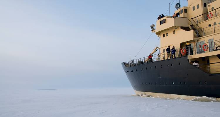 Navire brise-glace naviguant à travers un paysage gelé.