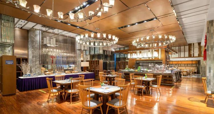 Elegantes Hotelrestaurant mit polierten Holzböden, modernen Kronleuchtern und ordentlich gedeckten Esstischen