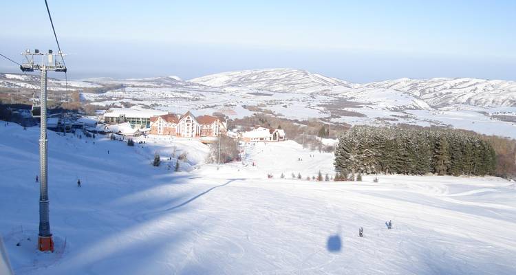 Ski resort with buildings and snowy mountains in the background.