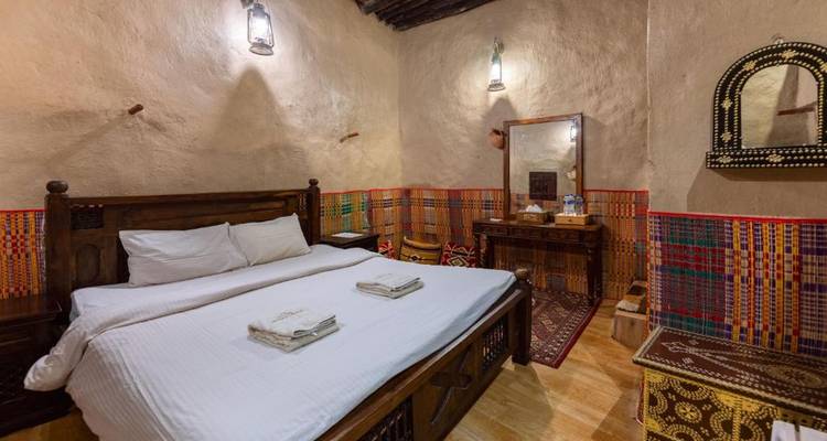 Chambre d'hôtel rustique avec décoration traditionnelle et mobilier en bois.