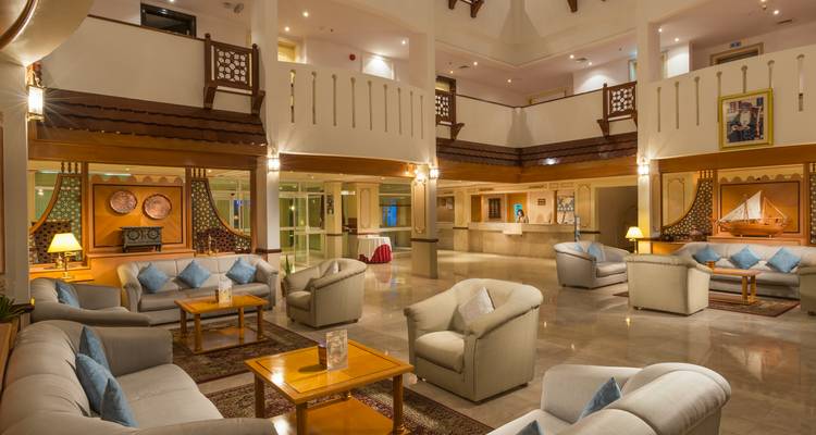 Luxuriöse Hotellobby mit Sofas und einem zentralen Kronleuchter.