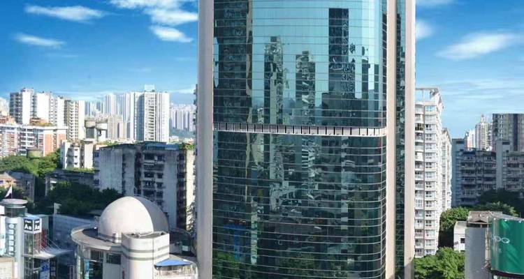 Grand gratte-ciel de verre avec des reflets d'autres bâtiments.