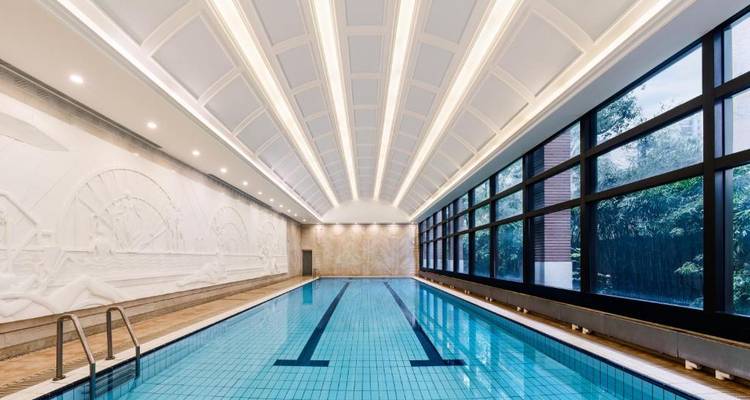 Piscine intérieure avec plafond élégant et fenêtres.