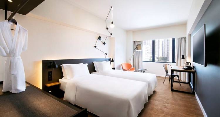 Chambre d'hôtel avec lits jumeaux et vue sur la ville.