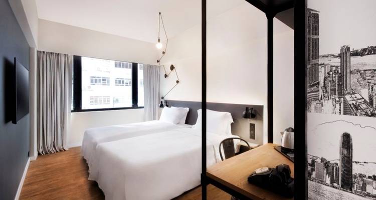 Chambre d'hôtel minimaliste avec lits jumeaux et décoration moderne.
