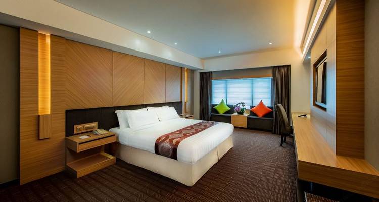 Chambre d'hôtel moderne avec un grand lit et des accents vibrants.