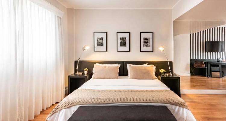 Modernes Hotelzimmer mit neutralen Farbtönen und großen Fenstern.