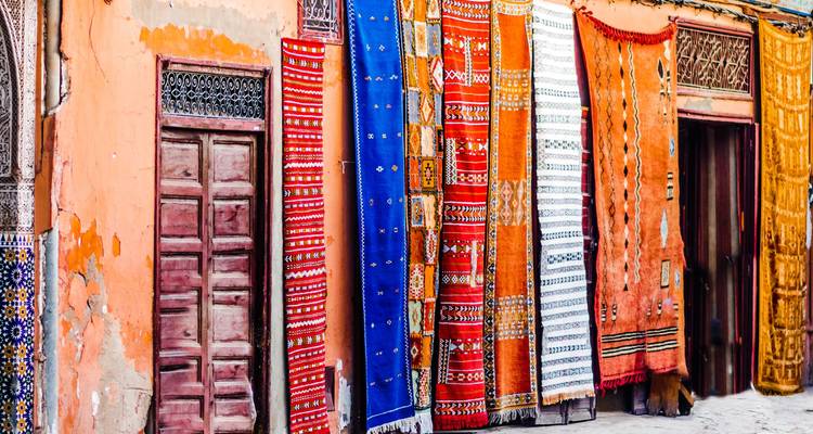 Tapis colorés et aux motifs complexes exposés sur un mur.