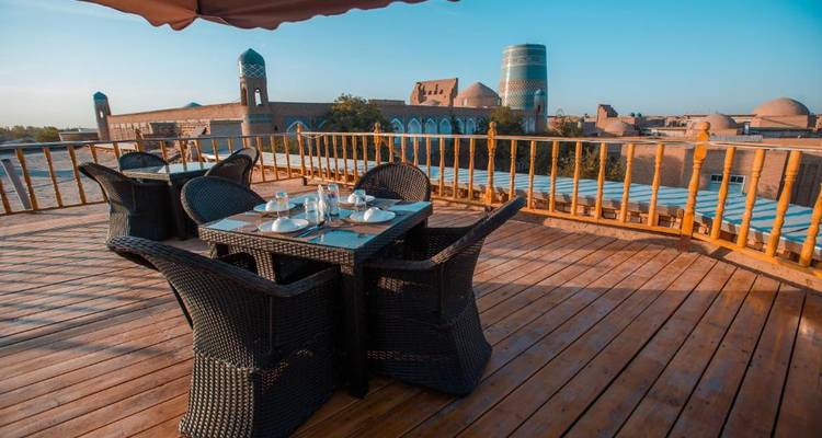 Zone de restauration en plein air avec vue sur les bâtiments historiques de Khiva.