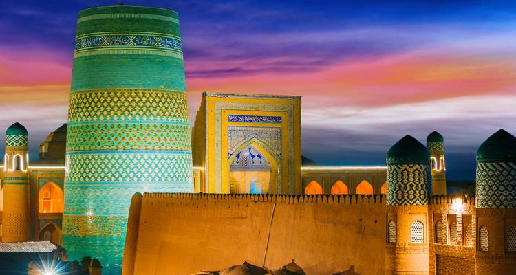 Dramatisch nachtgezicht van Khiva's turkooizen minaretten en muur.
