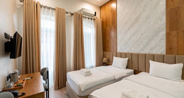 Hotelzimmer mit zwei Einzelbetten und stilvoller Einrichtung.