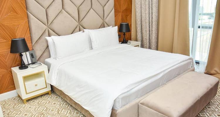 Configuration de chambre moderne avec mobilier clair et grandes fenêtres.