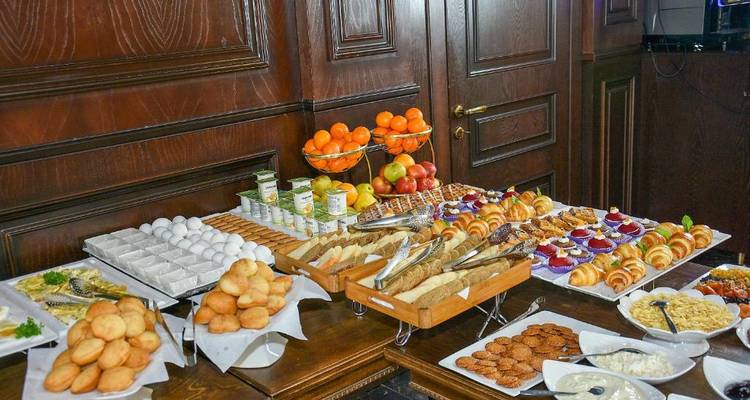 Configuration de buffet avec un assortiment d'aliments comprenant des pâtisseries et des fruits.