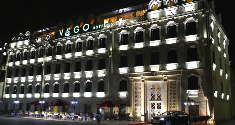 Beleuchtetes Hotelgebäude bei Nacht mit dekorativer Fassade.