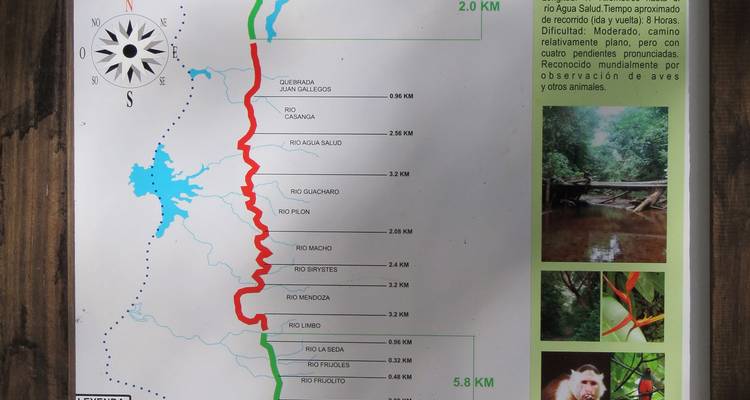 Vista cercana de un mapa informativo de sendero de senderismo con marcas de ruta y fotos de vida silvestre.