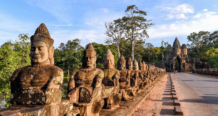 Alte Steinstatuen auf einer Brücke, die zu Angkor Wat führt.