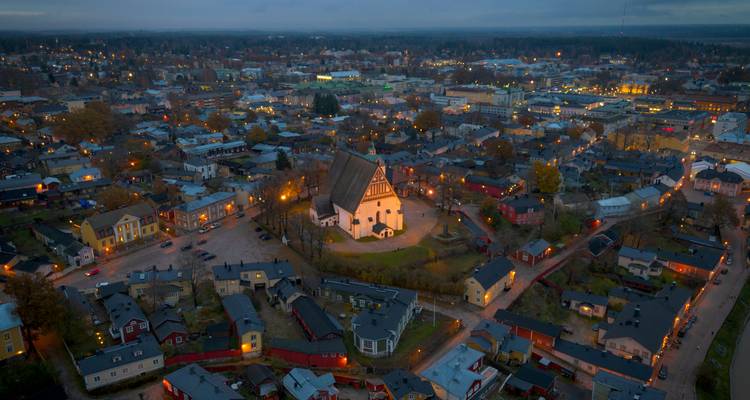 Aerial view of a town with a large church surrounded by streets lit at dusk.