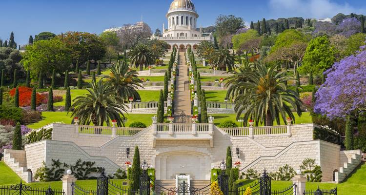 Beautiful landscaped gardens with a domed shrine in the background.