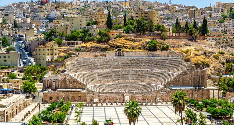 Römisches Amphitheater in Amman, Jordanien, umgeben von Stadtgebäuden.