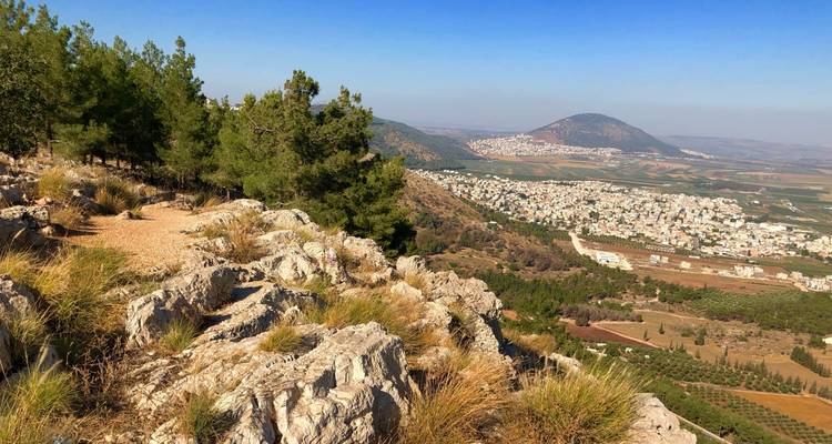 Vue de paysage vallonné avec une petite ville au loin.