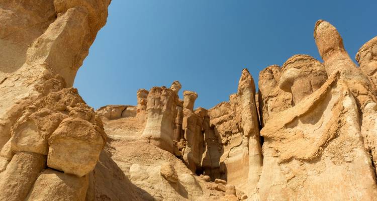 Rock formations in a desert under a clear blue sky.