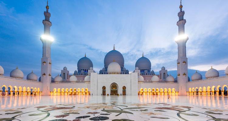 Mezquita del Jeque Zayed con sus cúpulas blancas y minaretes al atardecer.