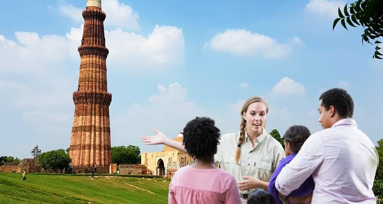 Des personnes visitant les alentours du Qutub Minar sous un ciel dégagé.