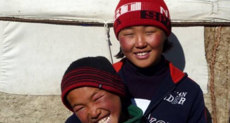 Deux personnes souriantes devant une yourte.