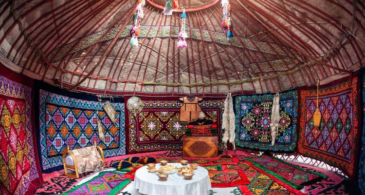 Intérieur de yourte traditionnelle décoré de textiles.