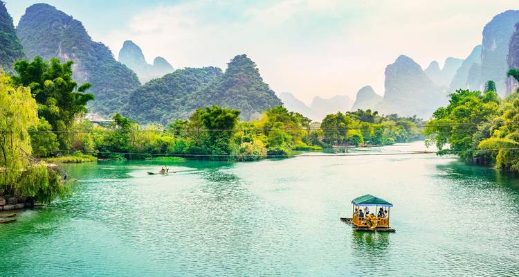 Scenic river landscape with karst mountains and a small boat.