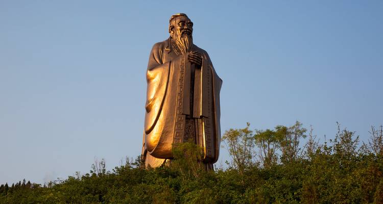 Estatua de Confucio contra un cielo azul despejado.