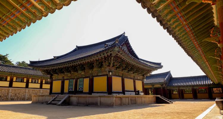 Patio tradicional de templo coreano con edificios ornamentados.