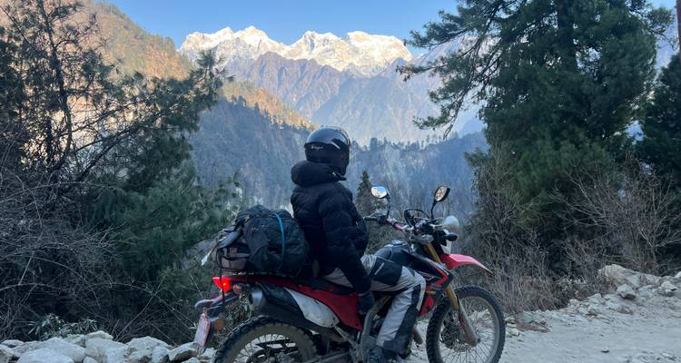 Person on a motorbike looking at mountains.