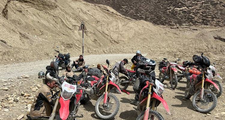 Bikers resting on a mountain road.