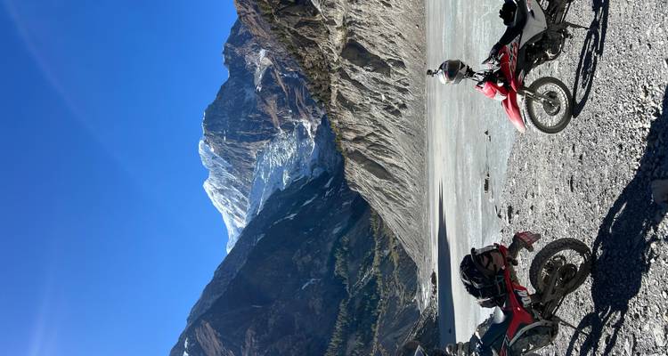 Motorcycles parked in front of a mountain with a glacier.