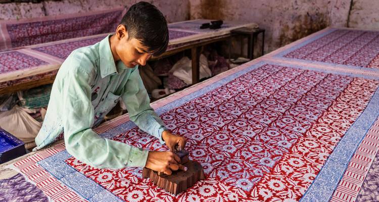 Personne créant des motifs à la main sur un tissu.