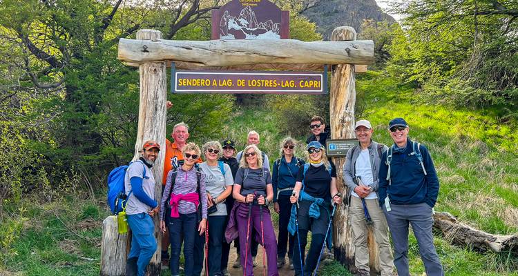 Un grupo de senderismo se para bajo un rústico letrero de madera que marca el sendero hacia la Laguna de los Tres cerca de El Chaltén.