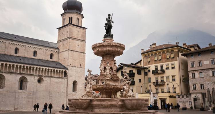 Plaza histórica con una fuente ornamentada y catedral.