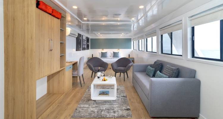 Bright, modern lounge and sleeping area aboard the yacht featuring contemporary furniture.