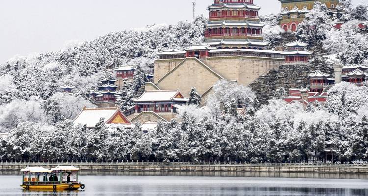 Zomerpaleis met met sneeuw bedekte bomen bij een meer.