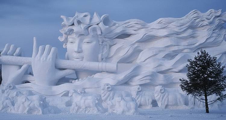 Ingewikkelde sneeuwsculptuur die een vrouw voorstelt die fluit speelt.