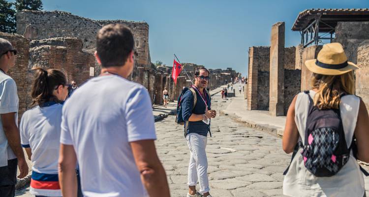 Une visite guidée à Pompéi avec des ruines et des touristes.