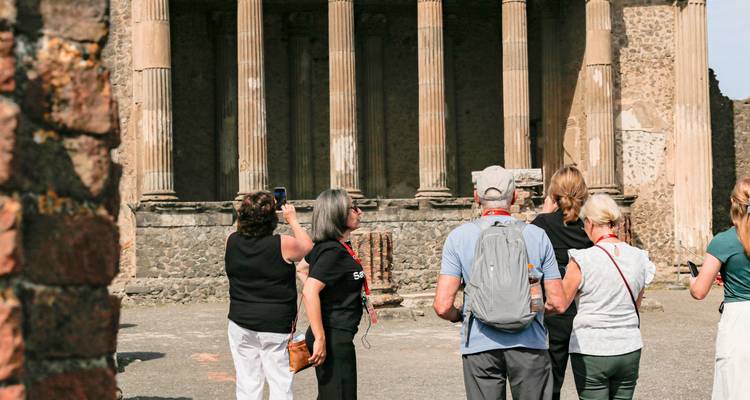 Touristes observant des colonnes et structures historiques.