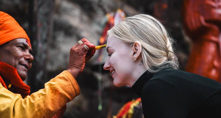 Mujer recibiendo un tilak de un monje.