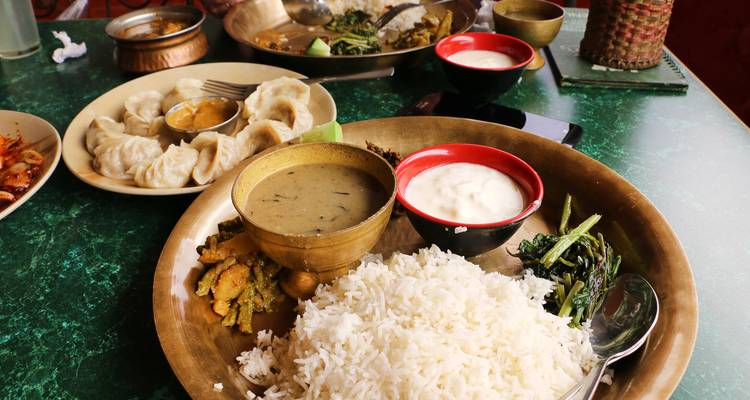 Comida nepalesa con arroz, verduras y salsas.