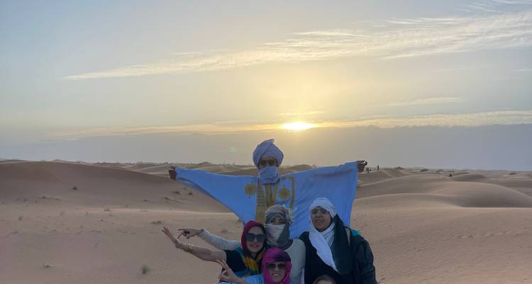 Groupe de personnes avec un drapeau dans le désert.
