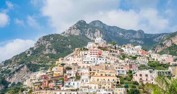 A hillside town with colorful buildings and mountains.