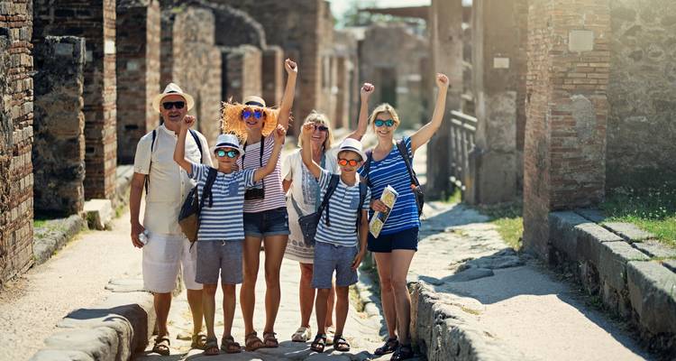 Cheerful family in matching striped shirts celebrating in the ancient streets of Pompeii.