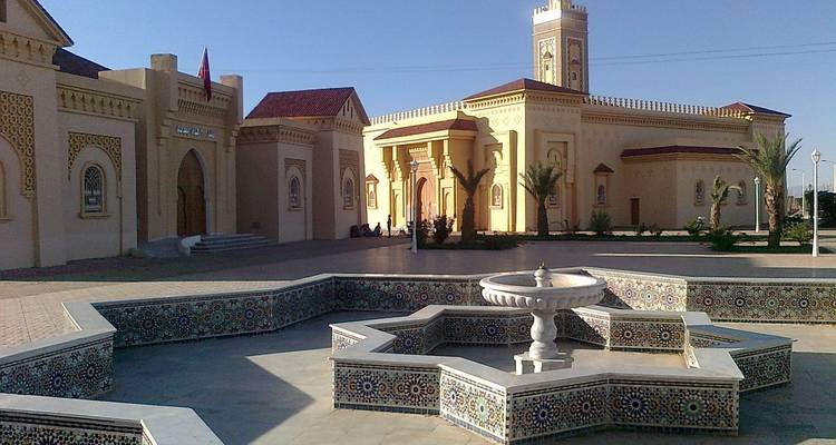 Un bâtiment avec une architecture marocaine traditionnelle et une fontaine.