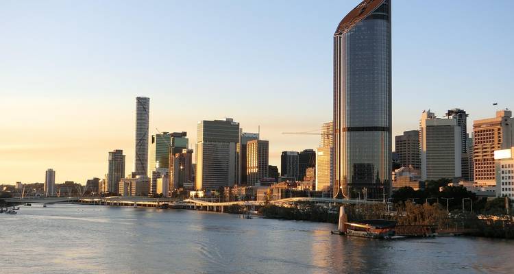 Stadshorizon met moderne gebouwen en een rivier.